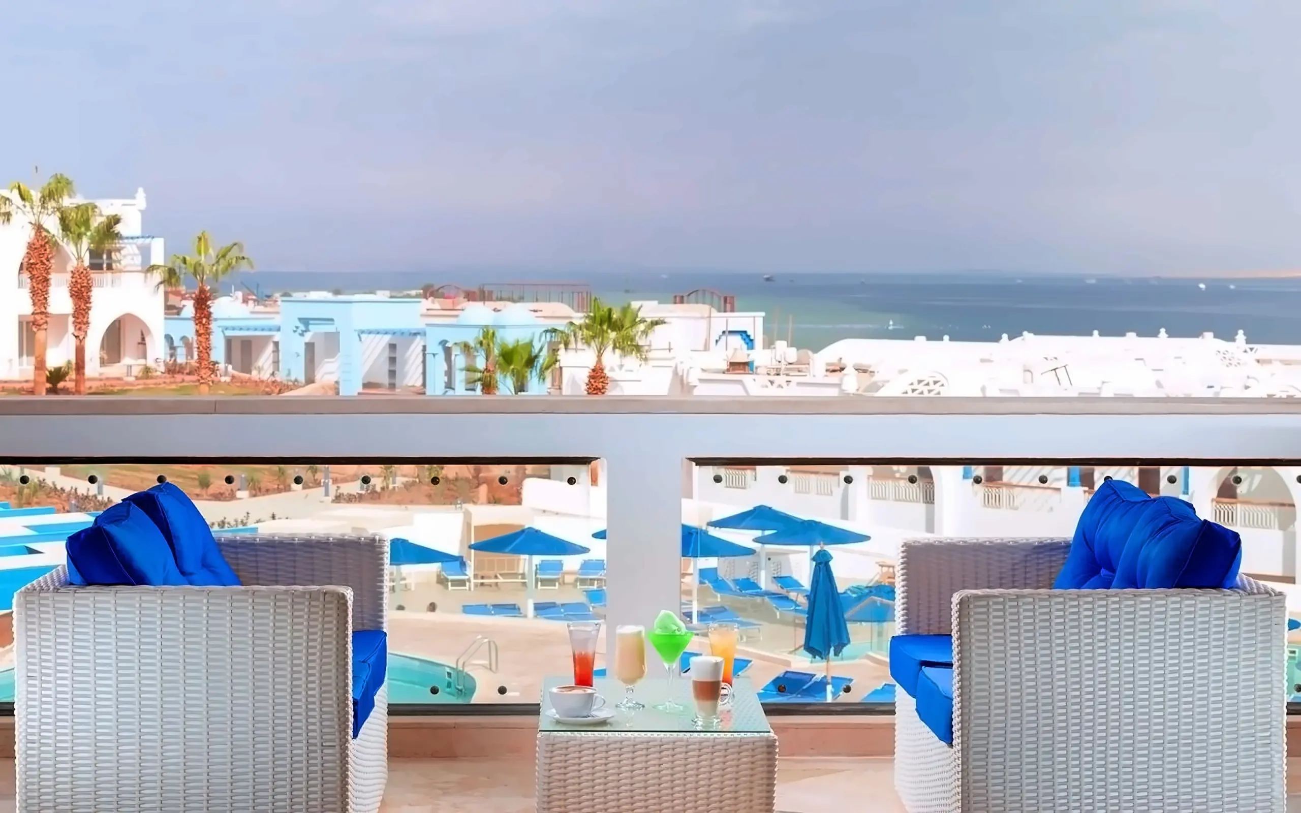 Балкон у готельному стилі: lounge-зона з правильними меблями і освітленням Готельний балкон з lounge-зоною, ліхтарями і видом на море - атмосфера повноцінного відпочинку