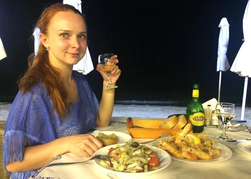 Стіл з традиційними грецькими стравами: грецький салат, мусака, морепродукти